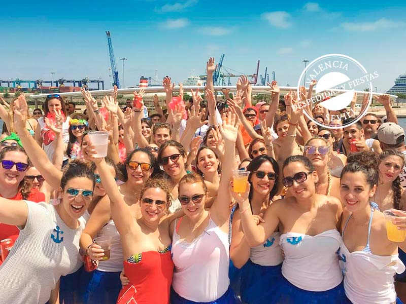 grupo de personas disfrutando de comida y fiesta en barco en Valencia